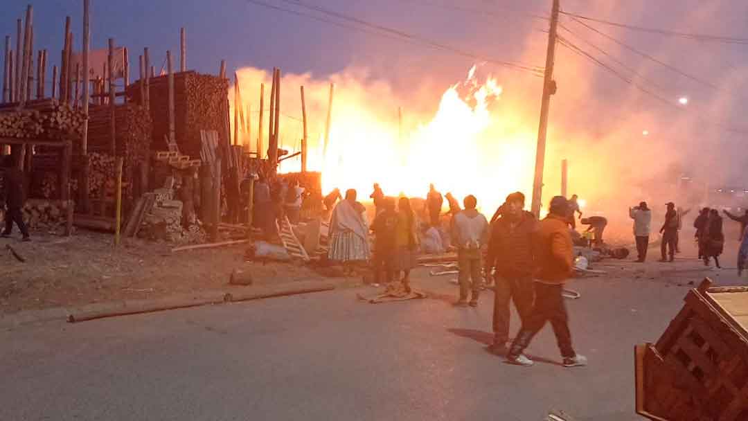 Vecinos ayudan a controlar el fuego retirando las maderas y palos que podría agravar el incendio en la zona Franca de El Alto